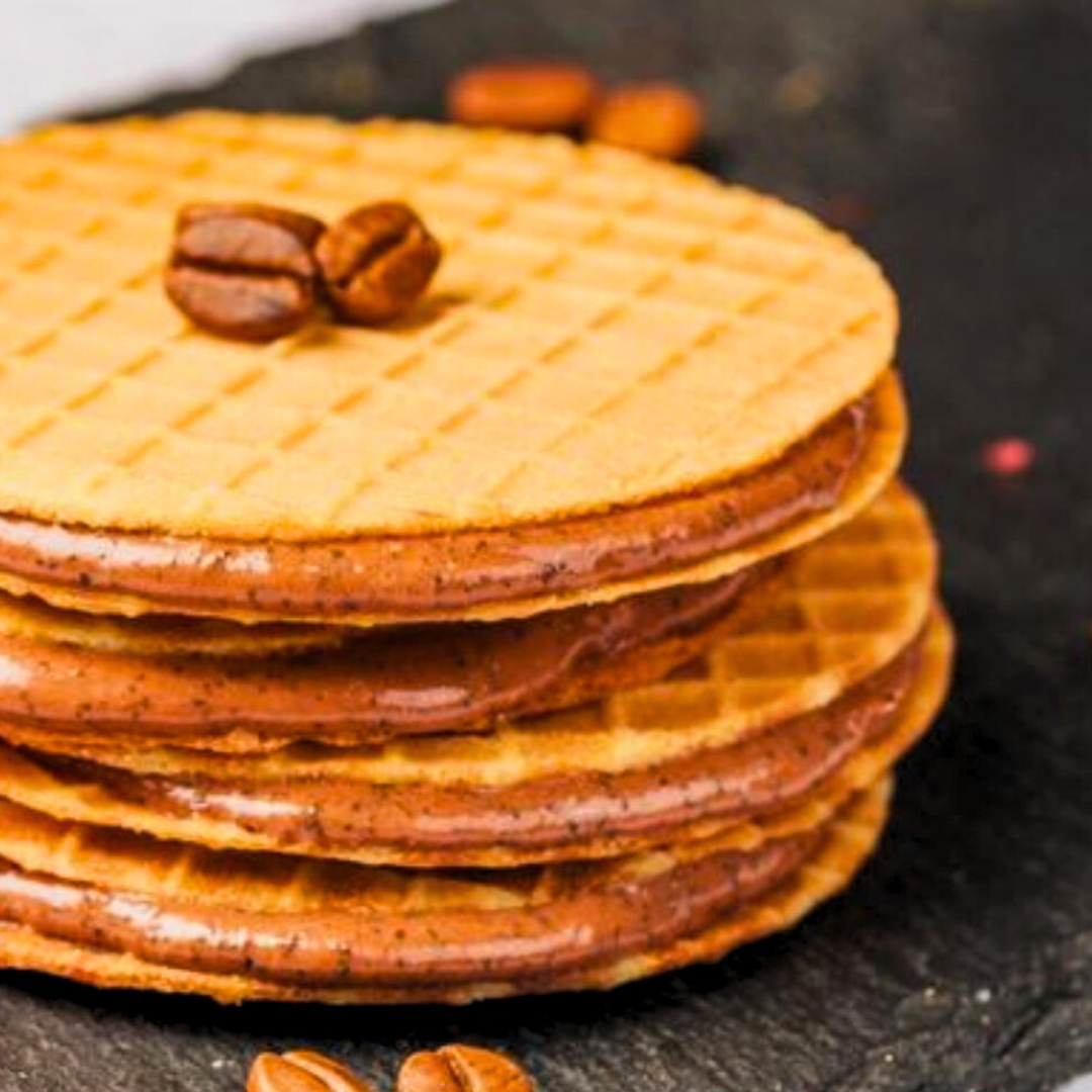 Stack of crunchy chocolate bites on a rustic wooden board.